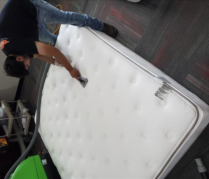 Team member cleaning a queen mattress